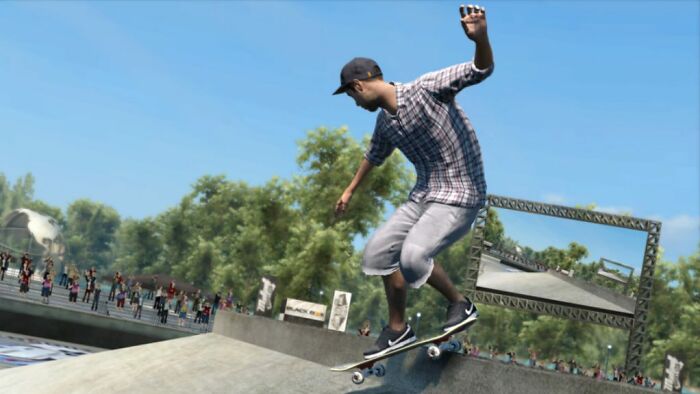 Gamer performing a skateboard trick in a virtual skate park with audience and outdoor trees in the background.
