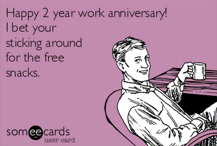 Man holding mug, smirking with text "Happy 2 year work anniversary! I bet you're sticking around for the free snacks," humorous meme.