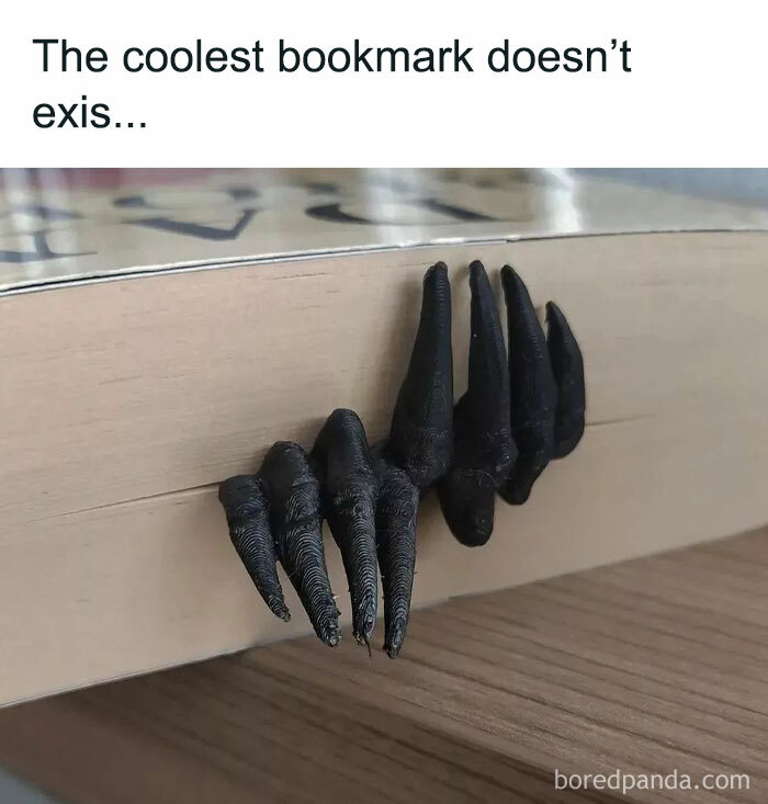 Black claw-shaped bookmark gripping the edge of a book, featured in 50 memes that make fun of almost everything.
