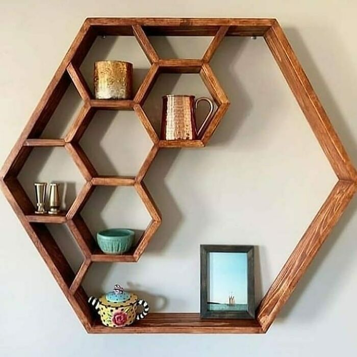Hexagonal wooden wall shelf crafted by woodworkers showcasing cool projects with decorative items and photo frame.