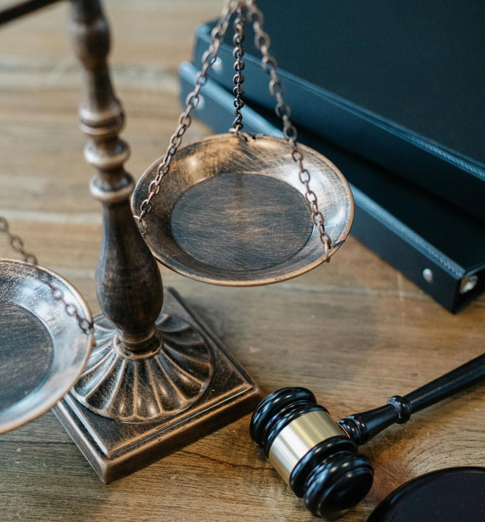 Scales of justice and judge gavel on wooden desk symbolizing jobs once respected but done by awful people.
