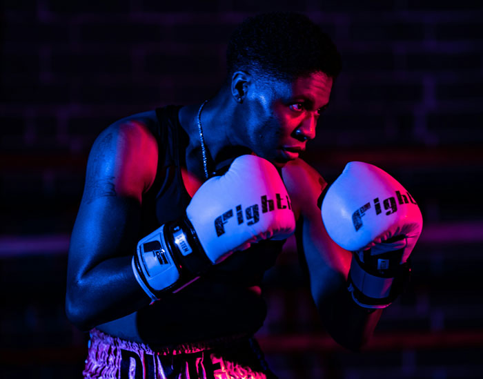 Boxer training intensely in a dimly lit gym, illustrating one of the 24 jobs that people once respected but realized are done by awful people.