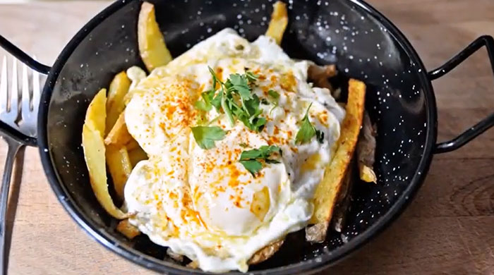 A Lunch idea featuring a skillet with crispy fries topped with poached eggs, garnished with parsley and sprinkled with paprika. A Lunch idea featuring a skillet with crispy fries topped with poached eggs, garnished with parsley and sprinkled with paprika.