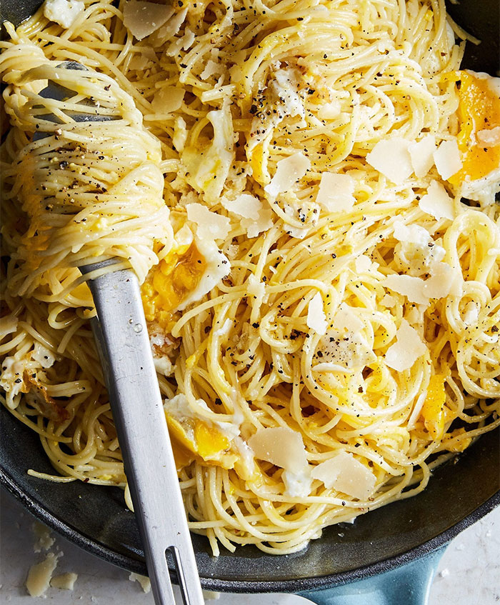 A Lunch idea featuring spaghetti mixed with fried eggs, topped with shaved Parmesan cheese and freshly ground black pepper. A Lunch idea featuring spaghetti mixed with fried eggs, topped with shaved Parmesan cheese and freshly ground black pepper.