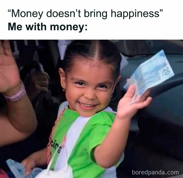 Smiling child holding money, illustrating a funny meme about happiness and wealth.