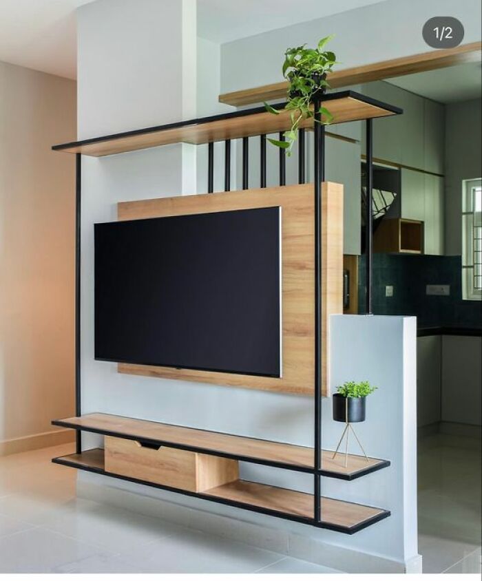Modern wall-mounted TV stand with wood and metal frame featuring shelves and decorative plants, showcasing woodworkers cool projects.
