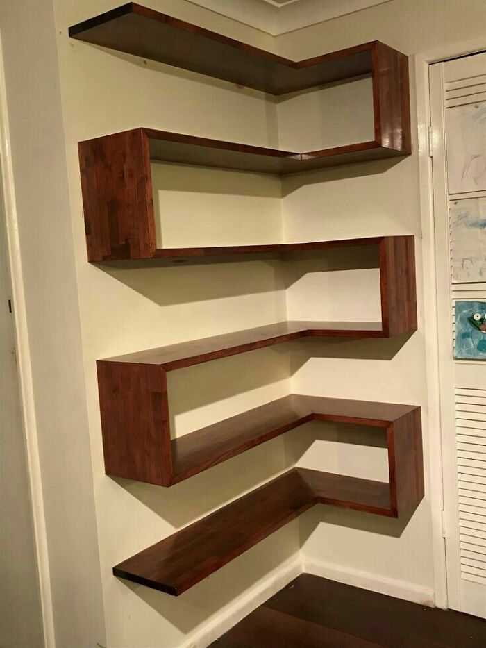 Floating wooden corner shelves with a modern design, showcasing a cool woodworking project shared by woodworkers online.