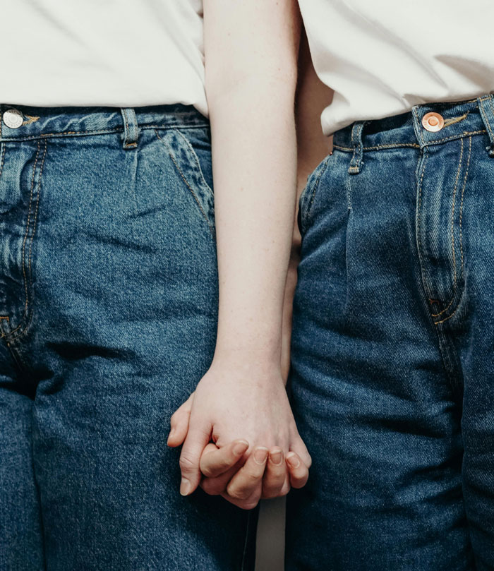 Two people holding hands closely, symbolizing connection and revealing chilling truths hidden in plain sight.