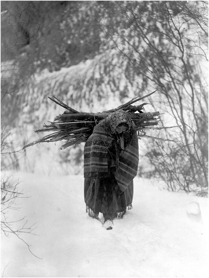 Woman carrying firewood in snowy landscape, an iconic historical and vintage photo shared in a Facebook group.