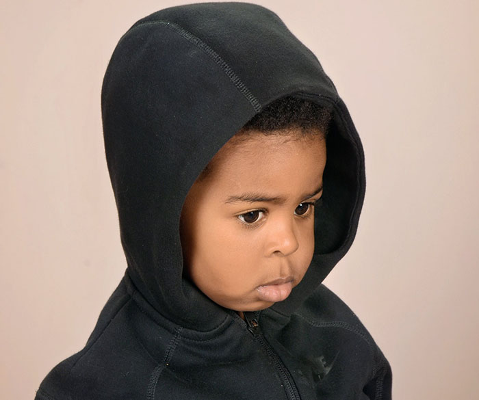Angry son wearing hoodie in amusing first school photo shared by mom.
