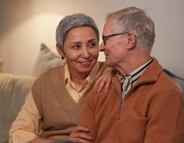 Older couple sharing a tender moment on a couch, illustrating key things women want men to finally understand.