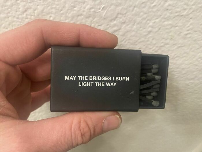 Hand holding a matchbox with black matches and a funny quote, fitting for memes that make fun of almost everything.