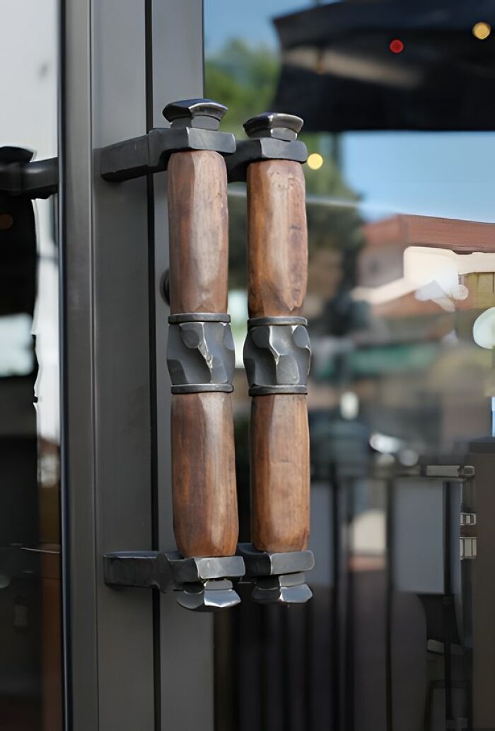 Woodworker project featuring handcrafted wooden door handles with metal accents on a glass door.