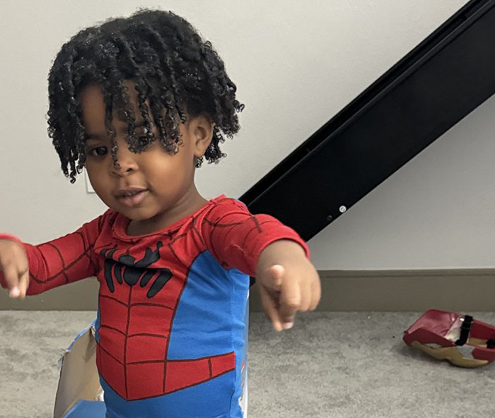 Angry son in Spider-Man costume playfully posing, capturing an amusing school photo moment.