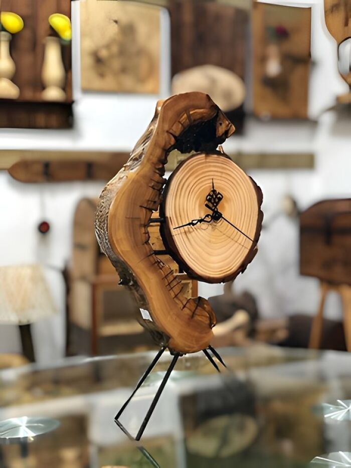 Woodworker project featuring a handcrafted wooden clock with natural rings and rustic metal stand on display.