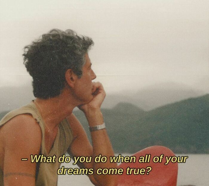 Man sitting pensively near water, reflecting, with the text "What do you do when all of your dreams come true?" in ‘90s style.