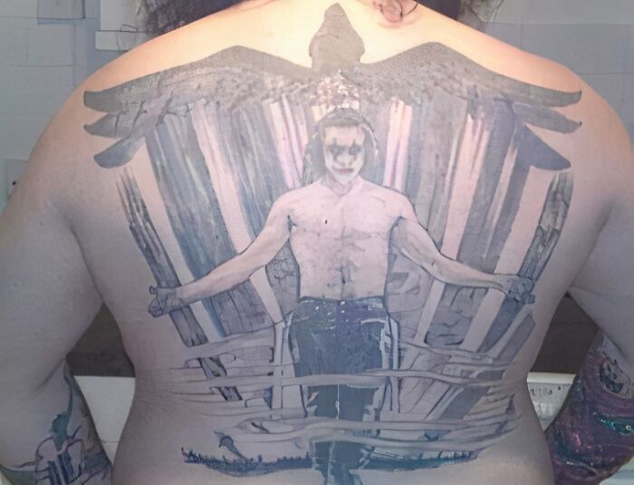 Back tattoo featuring a figure with outstretched arms and wings, shared in a Facebook group about unusual tattoos.