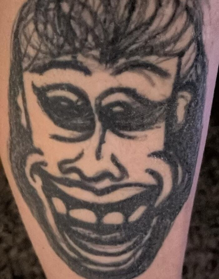 Tattoo showing a cartoonish face with exaggerated features, shared in a Facebook group.