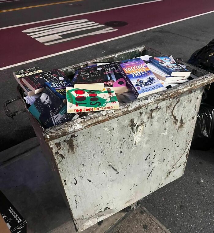 Books left on an NYC curbside treasure hunt in a metal bin.