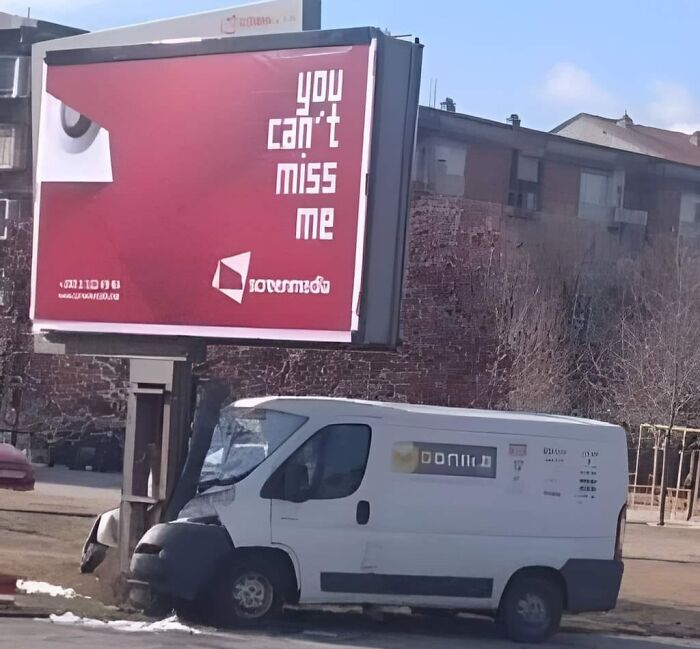 Van crashed into billboard with text "you can't miss me," illustrating a hilarious car-related meme.