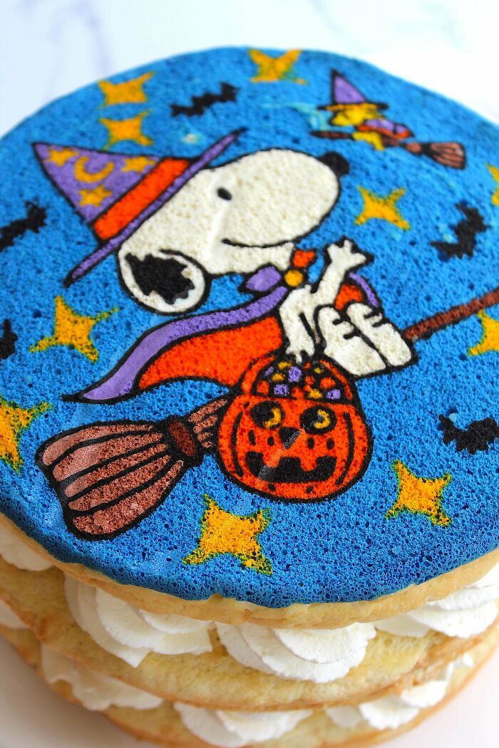 Halloween-themed decorated cake with Snoopy in a witch costume, showcasing creative baking at its finest.