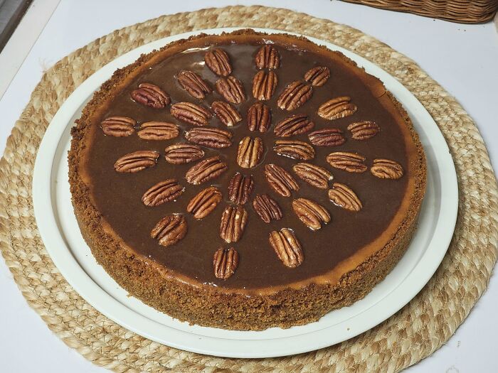 Chocolate pecan pie with a crumb crust on a white plate, showcasing baking at its finest and delicious dessert appeal.
