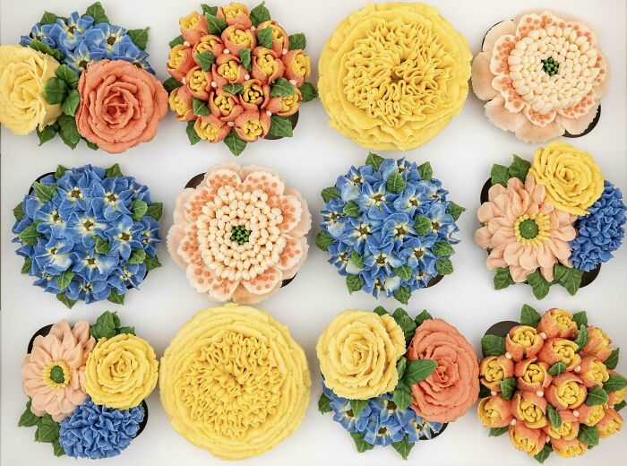 Assorted cupcakes decorated with colorful flower designs showcasing baking at its finest and artistic skill.