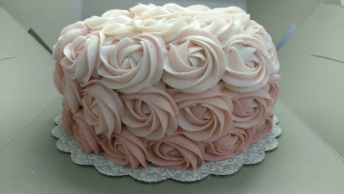 Decorative cake with pink buttercream roses showcasing baking at its finest in a detailed, elegant design.