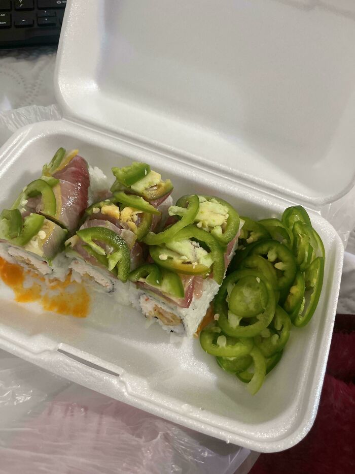 Takeout sushi with extra jalapeños, ordered by a customer, in a foam container.