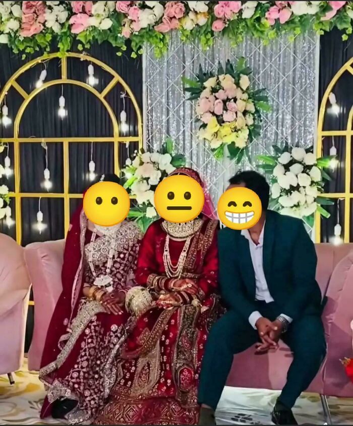 Emojis cover faces of three seated people at a colorful, decorated wedding.