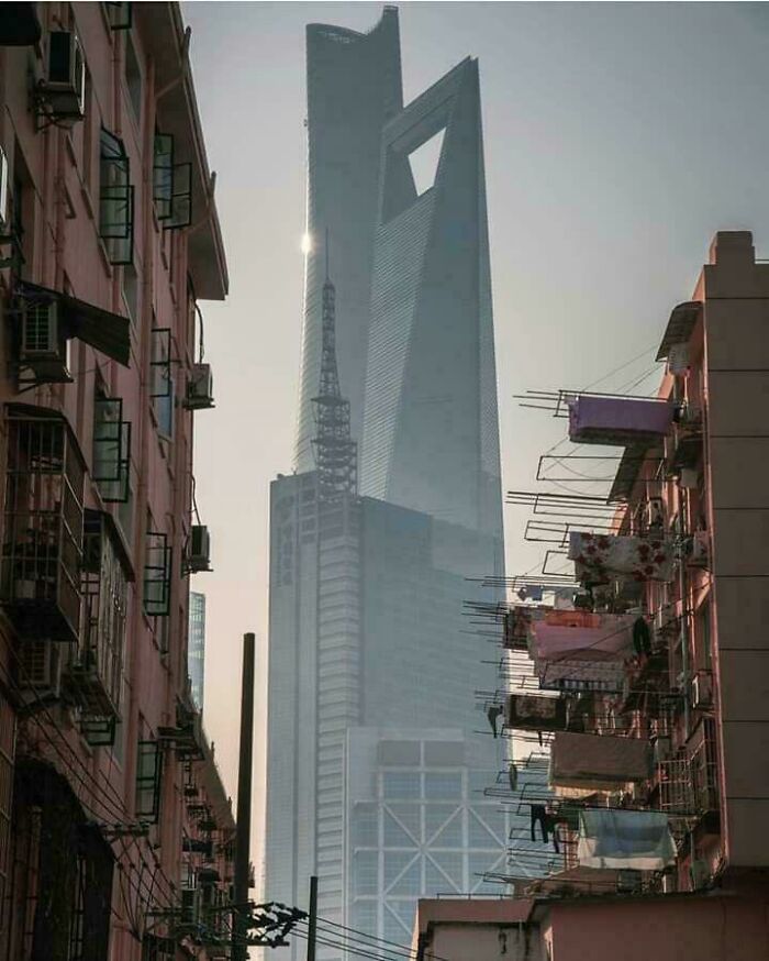Skyscrapers towering above old city buildings creating a striking scene that may trigger megalophobia fears.