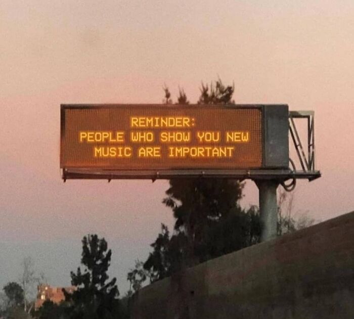 Highway sign at sunset humorously stating, "People who show you new music are important," adding a musical meme touch.