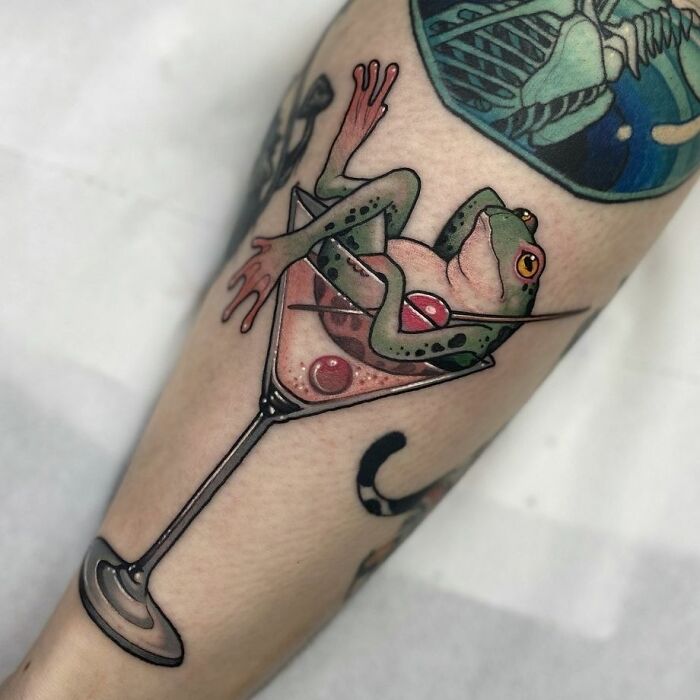 Frog tattoo with a martini glass, showcasing creative and adorable design on forearm.