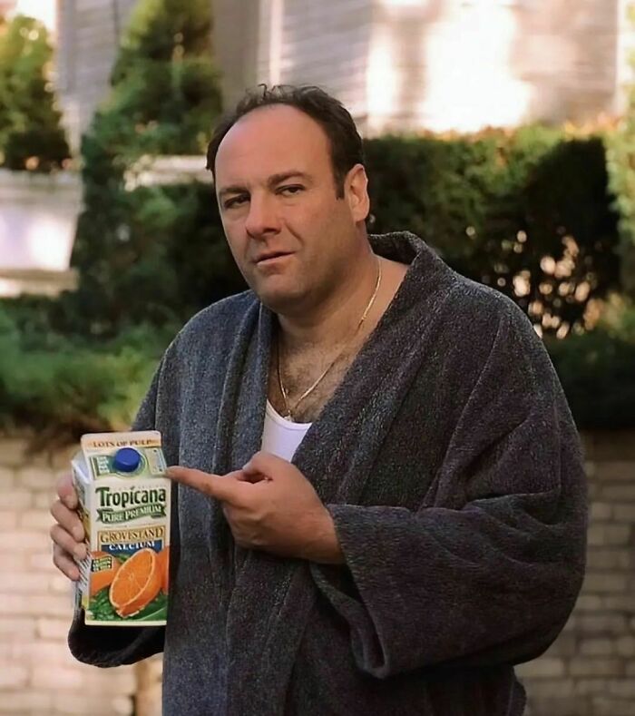Man in a robe holding a Tropicana juice carton, reminiscent of 90s moments.