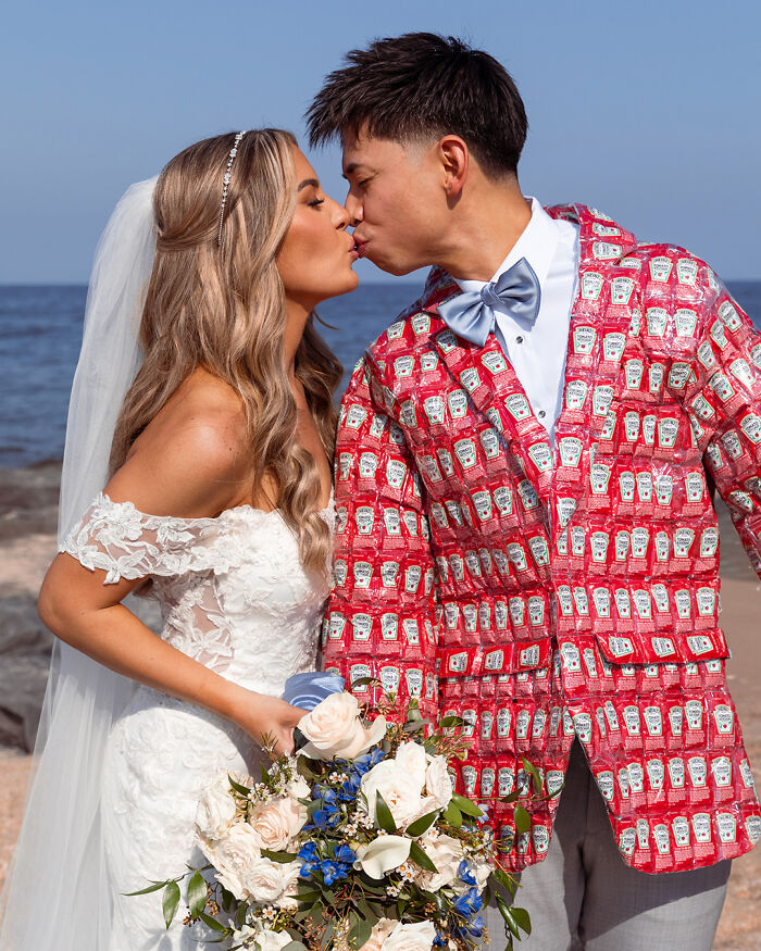 Bride in white wedding dress kissing groom wearing a DIY ketchup packet suit, showing a creative DIY disaster moment.
