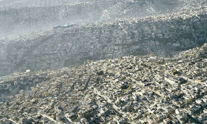 Aerial view of densely packed urban area, showcasing sprawling cityscape in a deteriorated environment.