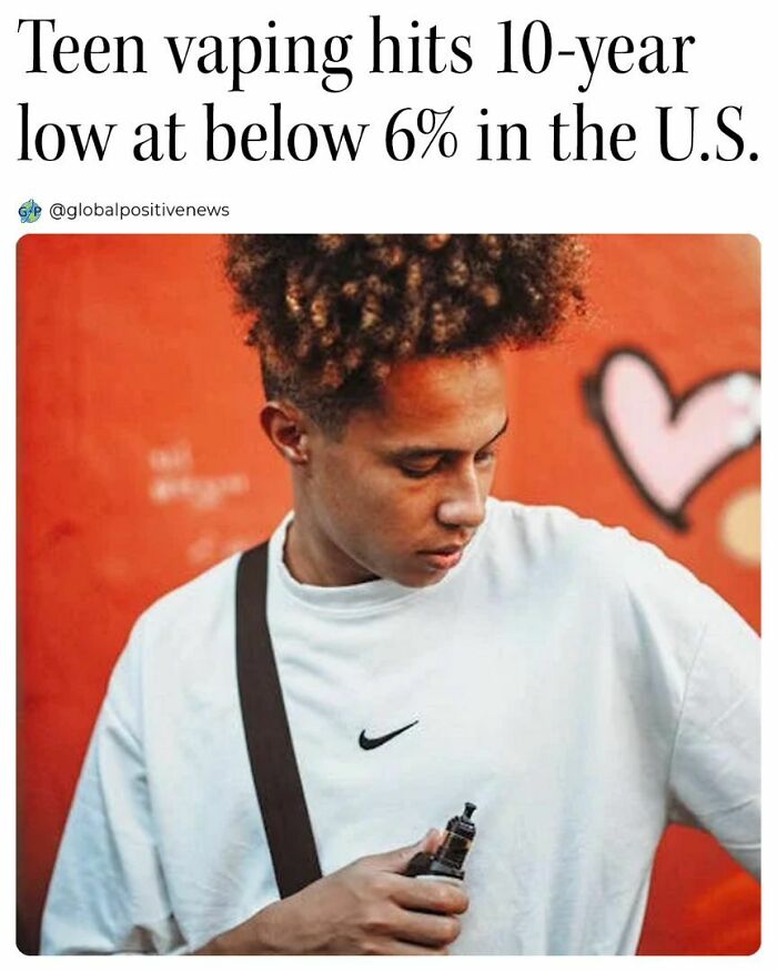 Young person holding a vape pen against a vibrant background, illustrating positive global news about reduced teen vaping.
