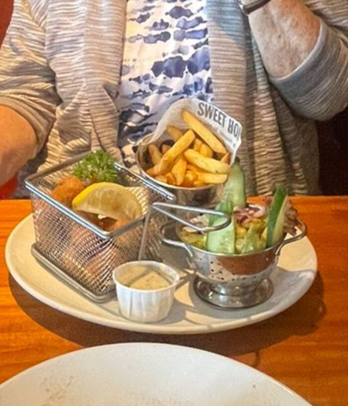 Food served in small metal baskets and a mini colander on a plate, showcasing ridiculous restaurant food presentation.