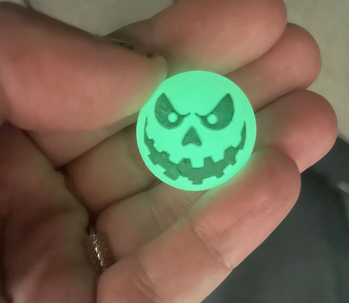Glowing Halloween non-candy treat in a hand featuring a spooky jack-o-lantern face for festive fall celebrations.