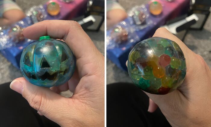 Hand holding a Halloween pumpkin-shaped stress ball filled with colorful beads, a popular non-candy treat idea.