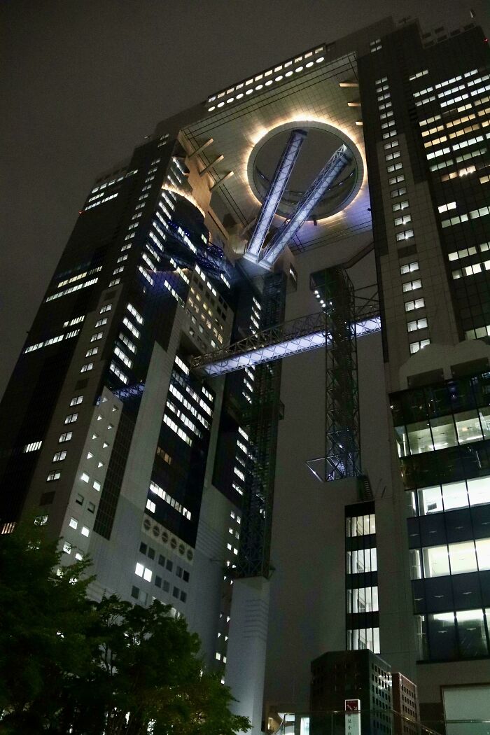 Night view of a towering building with eerie lighting and futuristic design, evoking supervillain headquarters vibes.