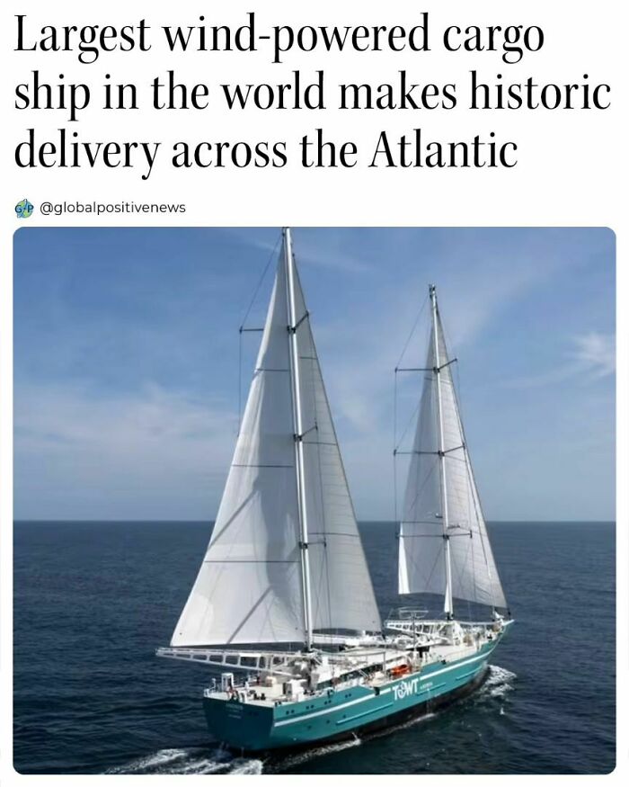Wind-powered cargo ship sailing across the Atlantic, symbolizing global positive news and innovation.