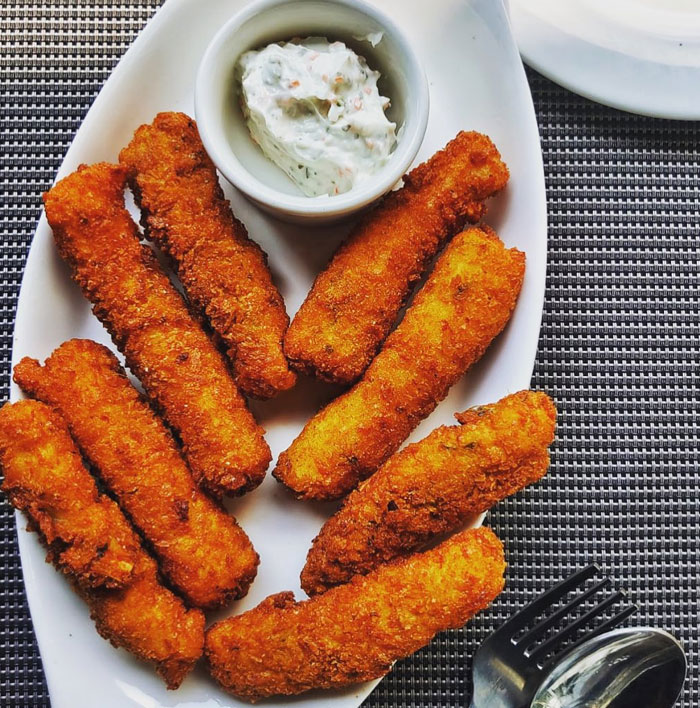 A Lunch idea featuring crispy golden fish fingers arranged on a white plate with a side of creamy dipping sauce, ready to serve. A Lunch idea featuring crispy golden fish fingers arranged on a white plate with a side of creamy dipping sauce, ready to serve.