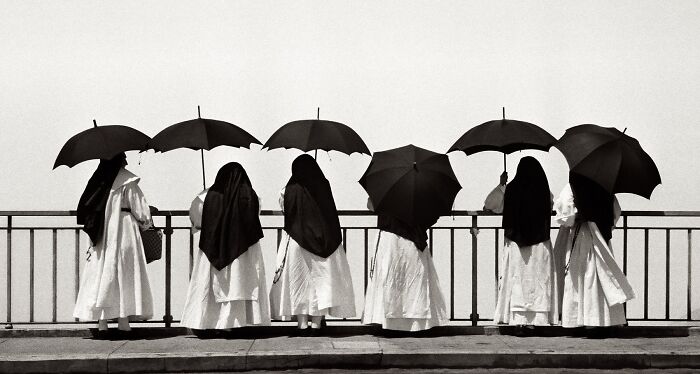 Vintage black and white photo of women holding umbrellas, showcasing historical and vintage photos from a popular FB group.