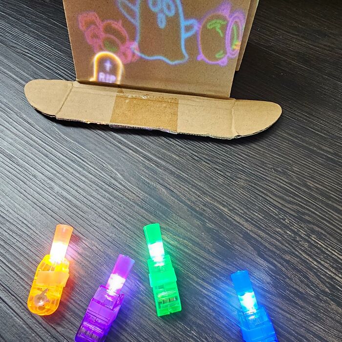 Colorful glowing light-up toys on a dark wooden surface as non-candy Halloween treats to avoid the blacklist.