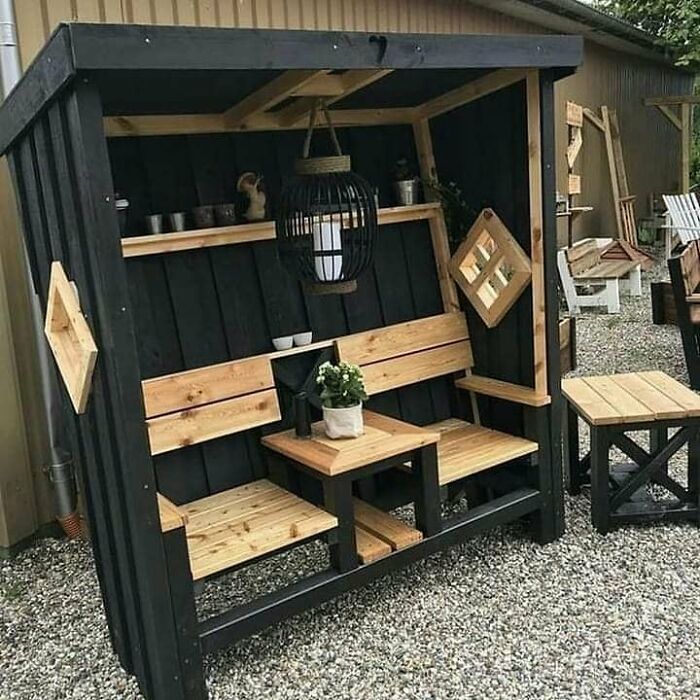Woodworker’s outdoor seating project featuring black and natural wood tones with a matched table and decorative elements.