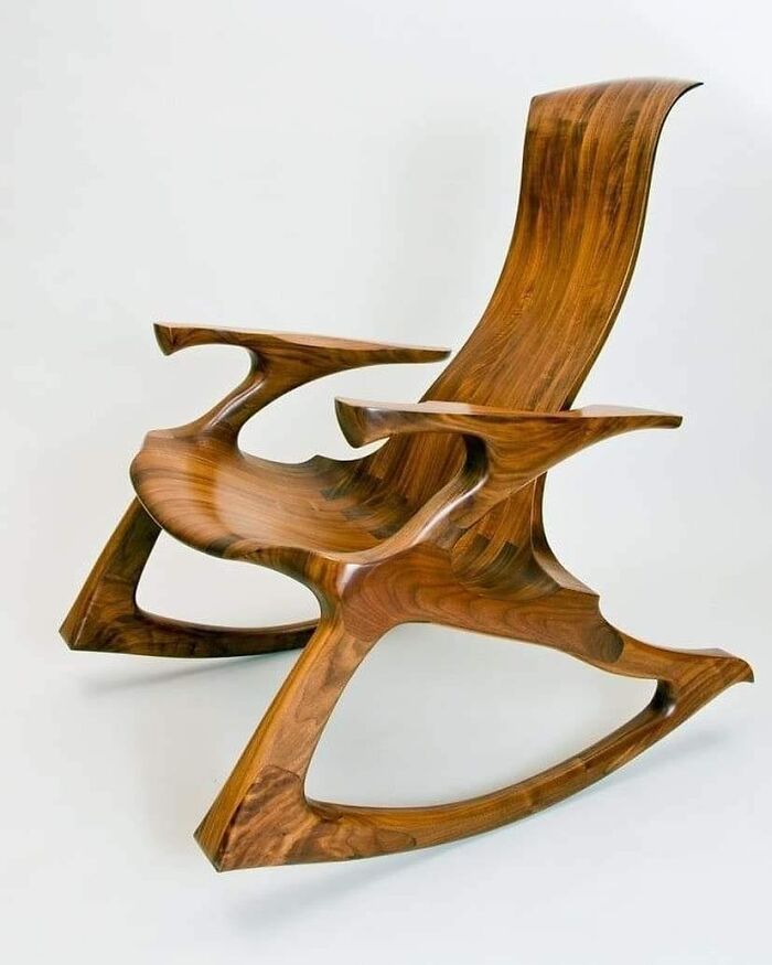 Sleek wooden rocking chair with smooth curves and polished finish showcasing expert woodworking craftsmanship.