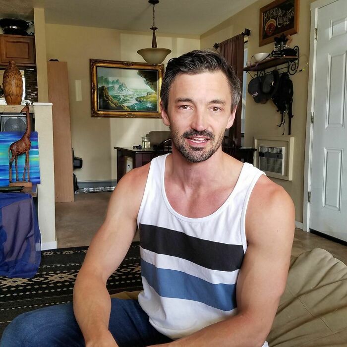 Man in a casual tank top sitting indoors, sharing one of the most moving stories from Humans of New York series.