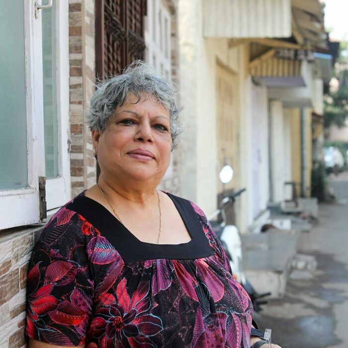 Elderly woman standing outdoors on a city street, representing moving stories from Humans of New York.