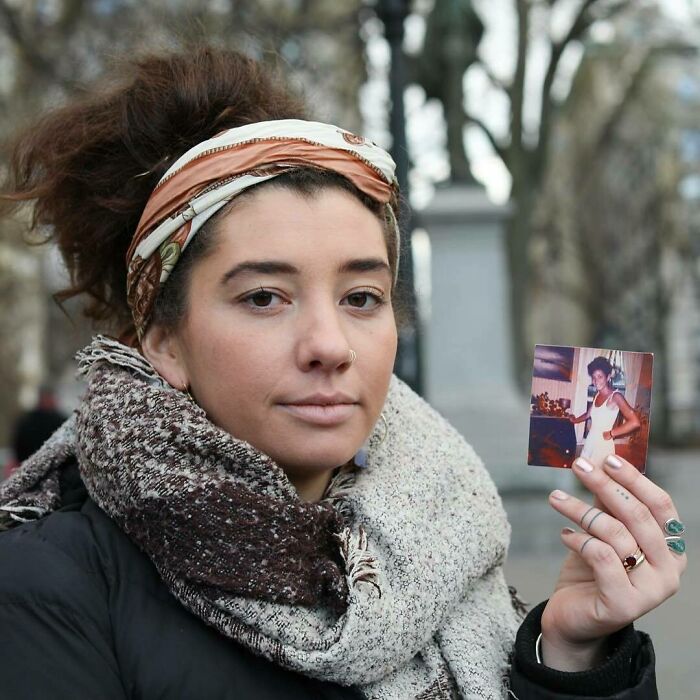 Young woman wearing a scarf and headband holding a photo, representing moving stories from Humans of New York.